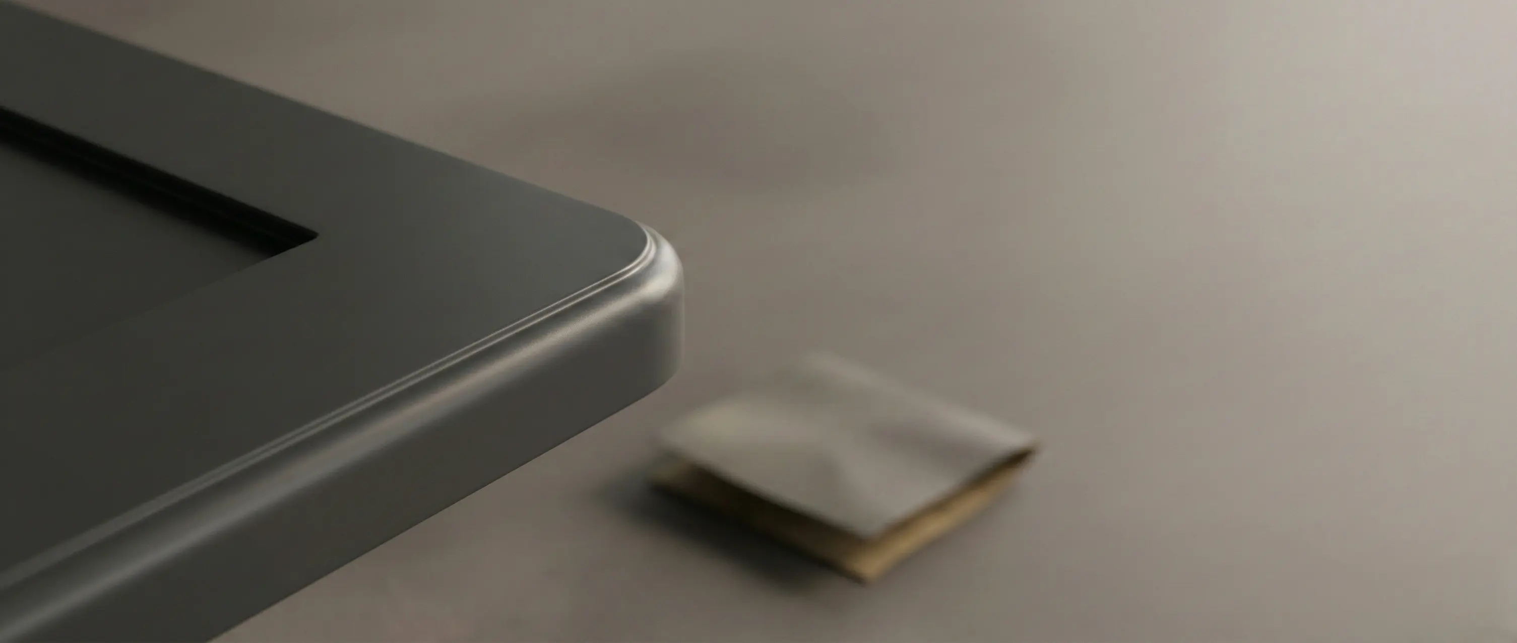 Close up of a satin wet coating finish on a radiused MDF edge, with a sanding pad blurred in the background.