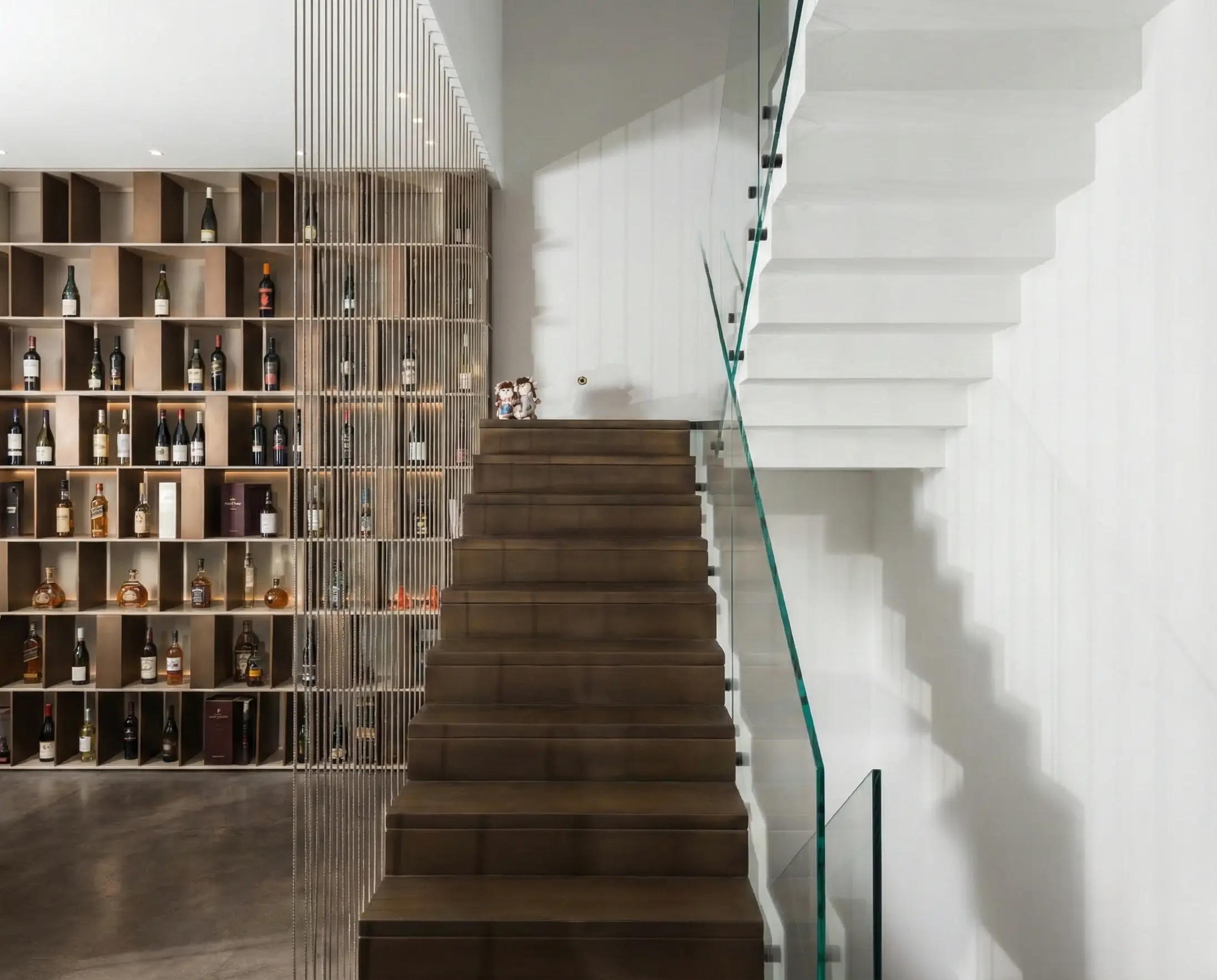 Bronze coated stair treads and risers with stainless cable railing in a residential interior.