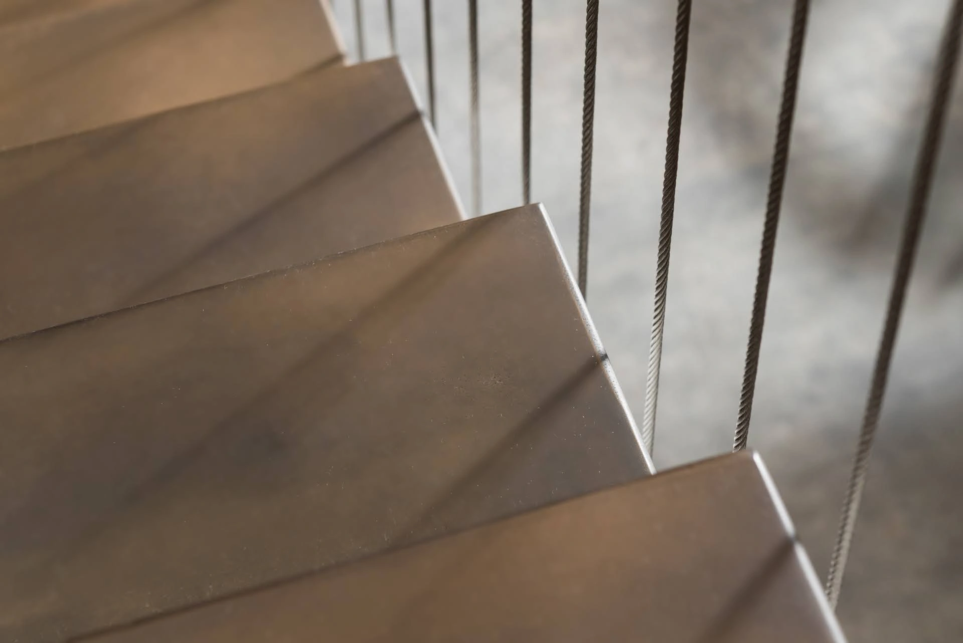 Close view of darkened bronze stair finish showing restrained sheen and subtle tonal variation.